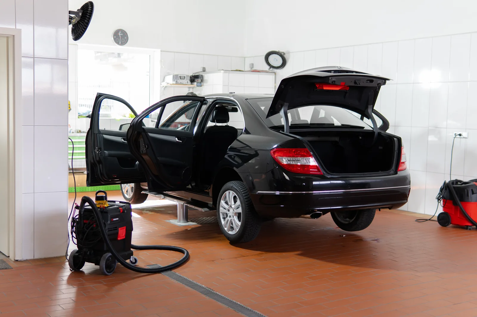 Werkstatt von Autohaus Arman mit Fahrzeug auf der Hebebühne während der Innenreinigung